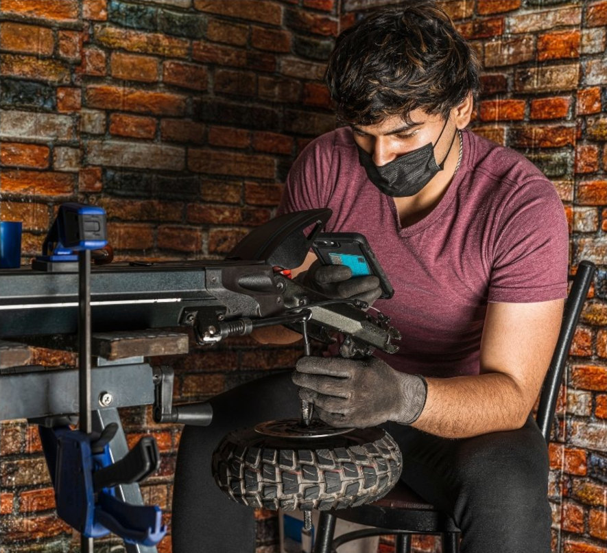 Kille reparerar elsparkcykel i sin verkstad